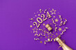 Creative Christmas and New Year background with golden champagne bottle, party decorations, confetti stars and 2024 numbers.