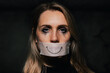 © ronstik - abuse and domestic violence. sad depressed woman hide her mouth behind fake drawn smile on paper tape. depression and mental health