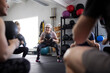 © Johnér - Senior woman with kettlebell exercising amidst people at health club
