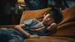 Asian teen boy feeling sick on couch taking a rest nap to feel better. Concept of Illness recovery, resting at home, recuperating, sick day at home, taking a nap, feeling unwell