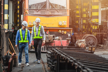 Wall Mural - Professional engineer mechanic team working together in locomotive train deport work checking train spare parts in the locomotive maintenance shop.