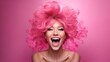 an overjoyed young woman with wild pink hair beams all over her face against a pink background