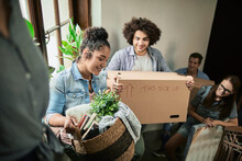 Diverse Group Of Young People Moving In Their New Shared Apartment And Carrying Boxes
