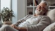© iuricazac - The senior citizen is at ease, relaxing on his living room sofa.
