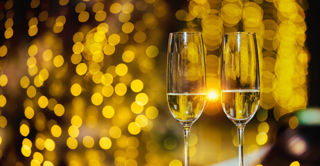 A glass of champagne on table with blur light in restaurant.