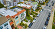 Fancy apartment buildings on street lined with cars aerial of San Francisco, CA