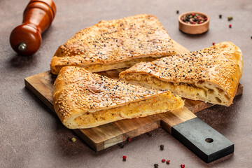 Canvas Print - pie with puff pastry, onions and potatoes on a wooden board. top view. copy space for text