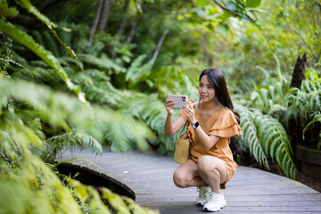 Wall Mural - Woman use cellphone to take photo in the park