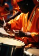 © Татьяна Креминская - Drummer at a Caribbean Carnival, rhythmically beating a steel drum adorned with bright ribbons