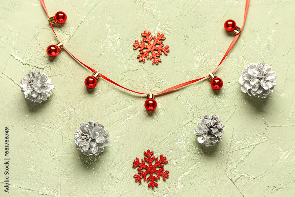 Christmas composition with pine cones, ribbon and balls on green grunge background