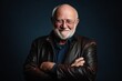 © Igor - Elderly man wearing a leather jacket on a dark background.