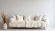 © Alin - Cozy cute sofa with white furry sheepskin fluffy throw and pillows against wall with copy space. Hygge, scandinavian home interior design of modern living room