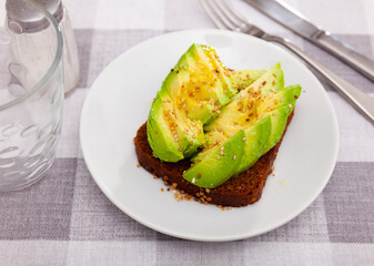 Wall Mural - Avocado sandwich served on table. Open sandwich with fresh green avocado.