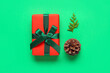 canvas print picture - Pine cone with coniferous branch and Christmas gift box on green background