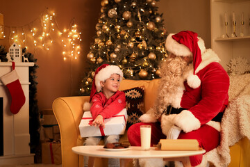 Canvas Print - Cute little boy with Christmas gift and Santa Claus at home