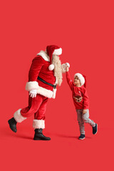 Sticker - Santa Claus and cute little boy dancing on red background