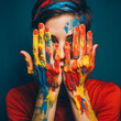 
Colorful portrait of a beautiful young girl on a dark background. The girl's entire face and hands are artistically painted with vibrant colors, showcasing creativity and the beauty of expression.