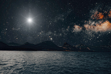 Wall Mural - star shines in the night sky over the sea on the holiday of christmas
