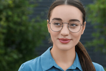 Canvas Print - Portrait of beautiful woman in glasses on blurred background. Attractive lady posing for camera. Space for text