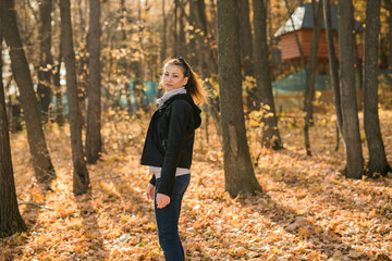 Wall Mural - Outdoor atmospheric lifestyle portrait of young beautiful young woman copy space. Warm autumn fall season. Millennial generation and youth