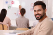 © New Africa - Happy man at desk in class during lesson in driving school. Space for text