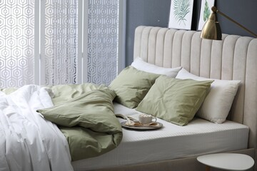 Sticker - Comfortable bed with new pistachio linens in modern room interior