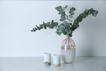 Sticker - Beautiful eucalyptus branches and candles on grey table, space for text. Interior element