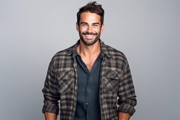 Wall Mural - Portrait of a handsome man smiling at the camera while standing against grey background