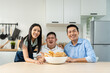 © Kawee - Asian happy family, mature parents baking bakery with son in kitchen.