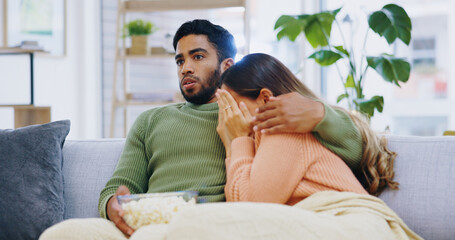 Poster - Fear, hug and couple watching tv on a sofa with popcorn for movie, film or streaming show at home. Wow, television and people embrace in living room with cinema snack for omg, horror or spooky series