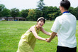 © Monet - Beautiful Asian couple laughing and frolicking happily hand in hand in a lush green park.