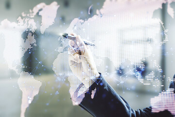Poster - Man hand with pen working with abstract creative digital world map on blurred office background, globalization concept. Multiexposure