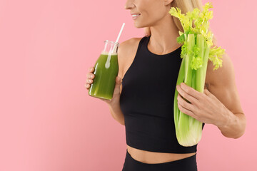 Poster - Woman with glass bottle of tasty celery juice and fresh vegetable on pink background, closeup. Space for text