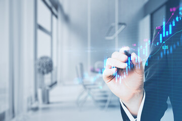Aufkleber - Close up of male hand with pen pointing at glowing upward candlestick forex chart on blurry grid office interior background. Trade, finance and money concept. Double exposure.
