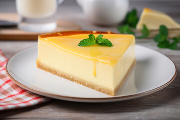 Piece of tasty cheesecake on plate on wooden table, closeup