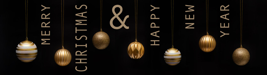 Wall Mural - Merry Christmas & happy new year greeting card panorama - Group of hanging gold golden Christmas balls Christmas baubles ornaments, isolated on black background