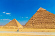 Woman tourist looking at the Great Pyramids of Egypt.