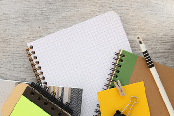 Wall Mural - Top view of blank notepad placed near office supplies, notepad with sticky notes and on wooden table