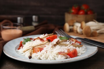 Delicious rice with bacon, mushrooms and tomatoes served on table, closeup