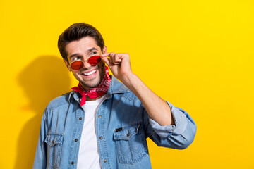Poster - Photo of cool pleasant guy wear jeans jacket touch glasses look at black friday promotion empty space isolated on yellow color background