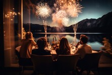  A Group Of People Sitting At A Table In Front Of A Window With A View Of A Lake And Fireworks In The Sky At Night Time Of The Day And Night.