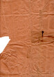 Zerknittertes altes rötliches Packpapier mit Knicken und Flecken