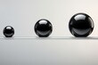  a group of three black balls sitting on top of a white surface with one black ball in the middle of the group and one black ball in the middle of the group.