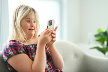 portrait of beautiful little girl having down syndrome using cellphone