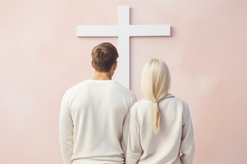 Wall Mural - Back of fashion family couple in white clothes looking at the Cross of Jesus. Church, worship, christianity concept. Men and woman, husband, wife, bride, groom, guy and girl on pastel background