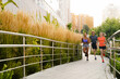 © Drobot Dean - Group of three young people jogging together on city bridge