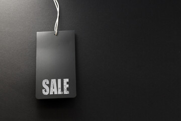 SALE word on black tags and black blank background.