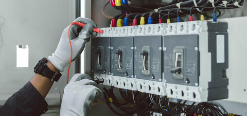 Wall Mural - Electrician engineer tests electrical installations and wires on relay protection system.