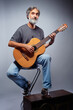 © luengo_ua - Aged bearded man with an acoustic guitar