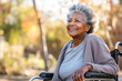 Portrait of a smiling elderly African American female lady sitting in a wheelchair in a urban park